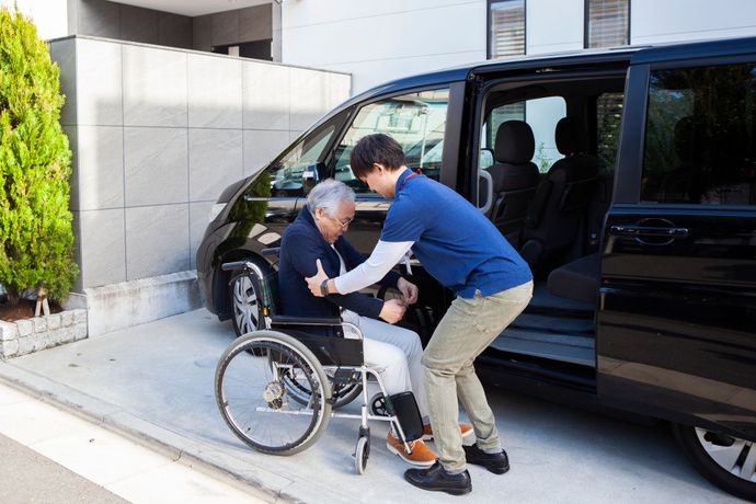 Man helps an elderly man in wheelchair into a van – New Ulm, MN – Minne Transportation Service