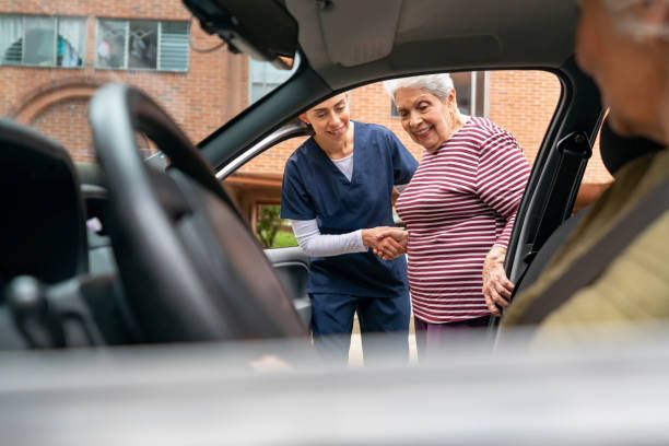 Caregiver helping a senior woman get in a car – New Ulm, MN – Minne Transportation Service