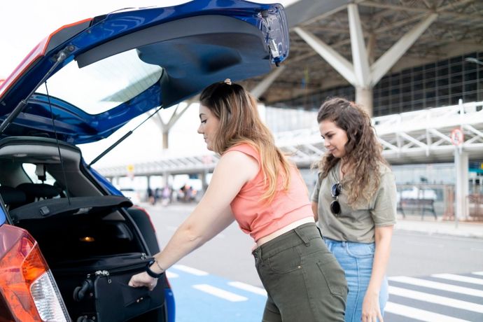 Two women are loading luggage into the back of a car – New Ulm, MN – Minne Transportation Service