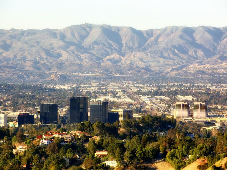 An aerial view of a city with mountains in the background