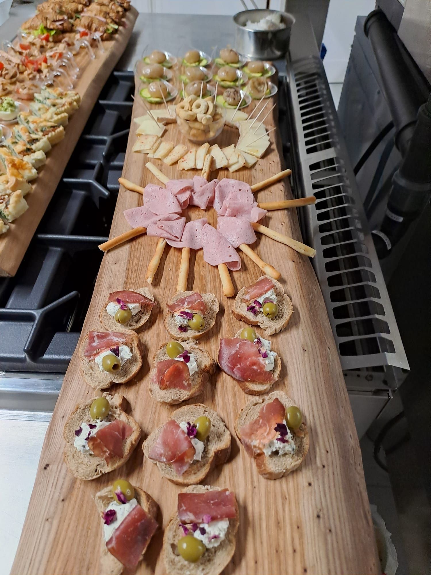 Tagliere di salumi in legno con antipasti: formaggi, carni, olive e pane.