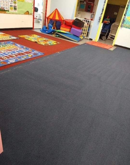 Childcare classroom with mats of different colors and toys in the background.