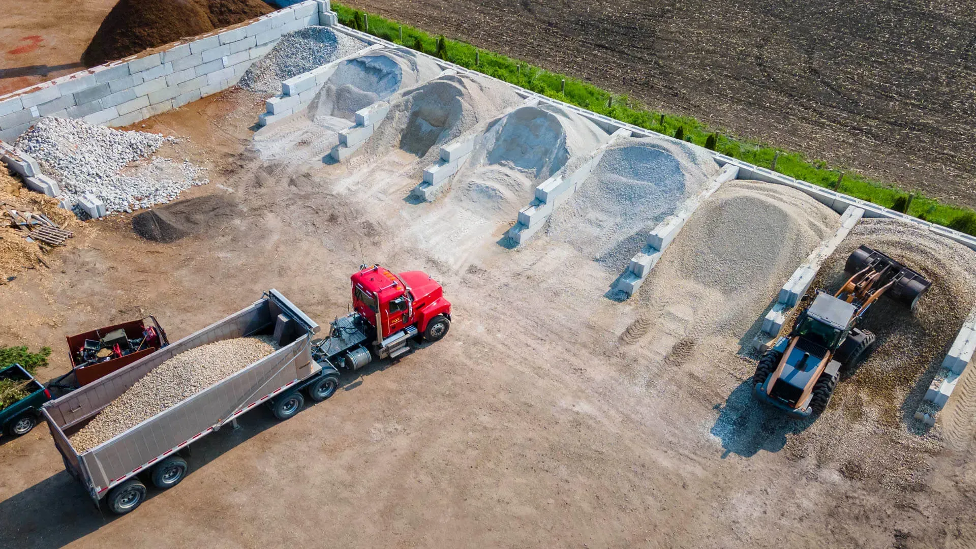 A construction worker wearing orange gloves is pouring concrete on a construction site.
