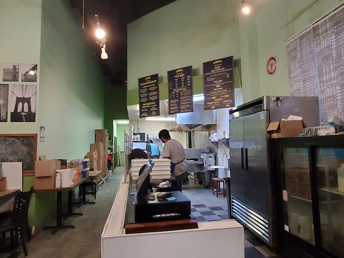 The inside of a restaurant with a man behind a counter