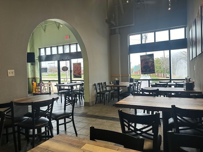 A restaurant with tables and chairs and a large window.