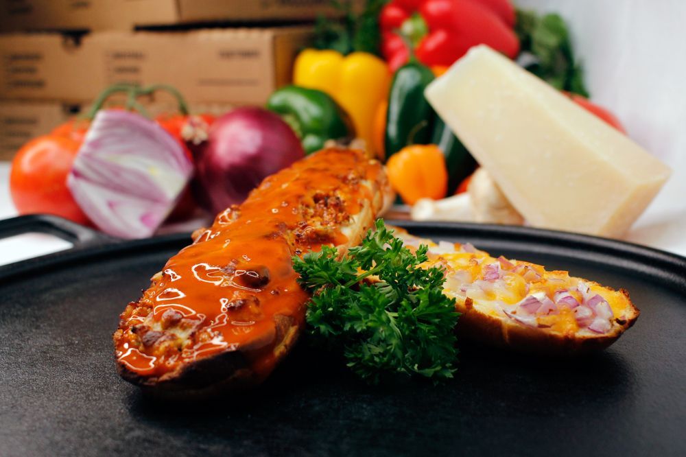 A close up of a plate of food with vegetables in the background
