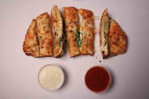 A close up of a pizza with sauce on a table.