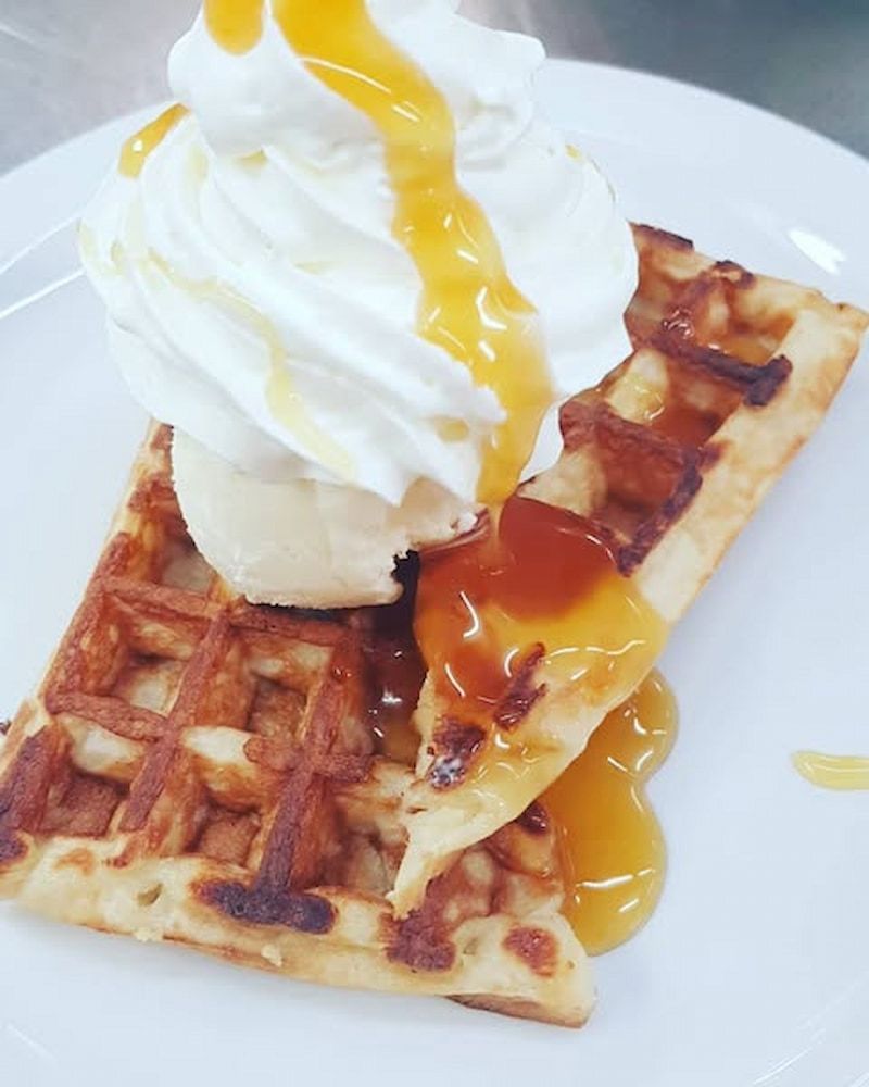 A Waffle With Whipped Cream And Caramel Sauce On A White Plate — Inverell Sporties in Inverell, NSW
