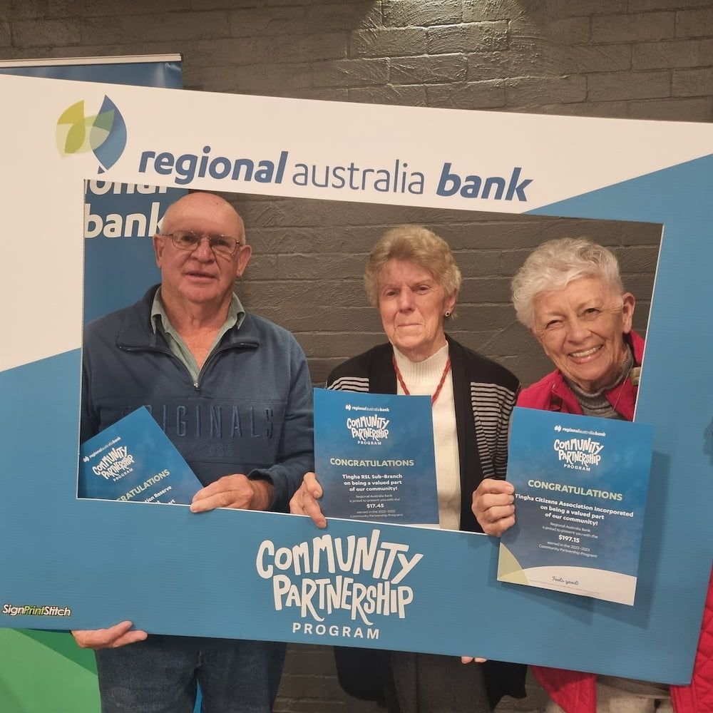 A Group Of People Holding A Sign That Says Community Partnership — Inverell Sporties in Inverell, NSW