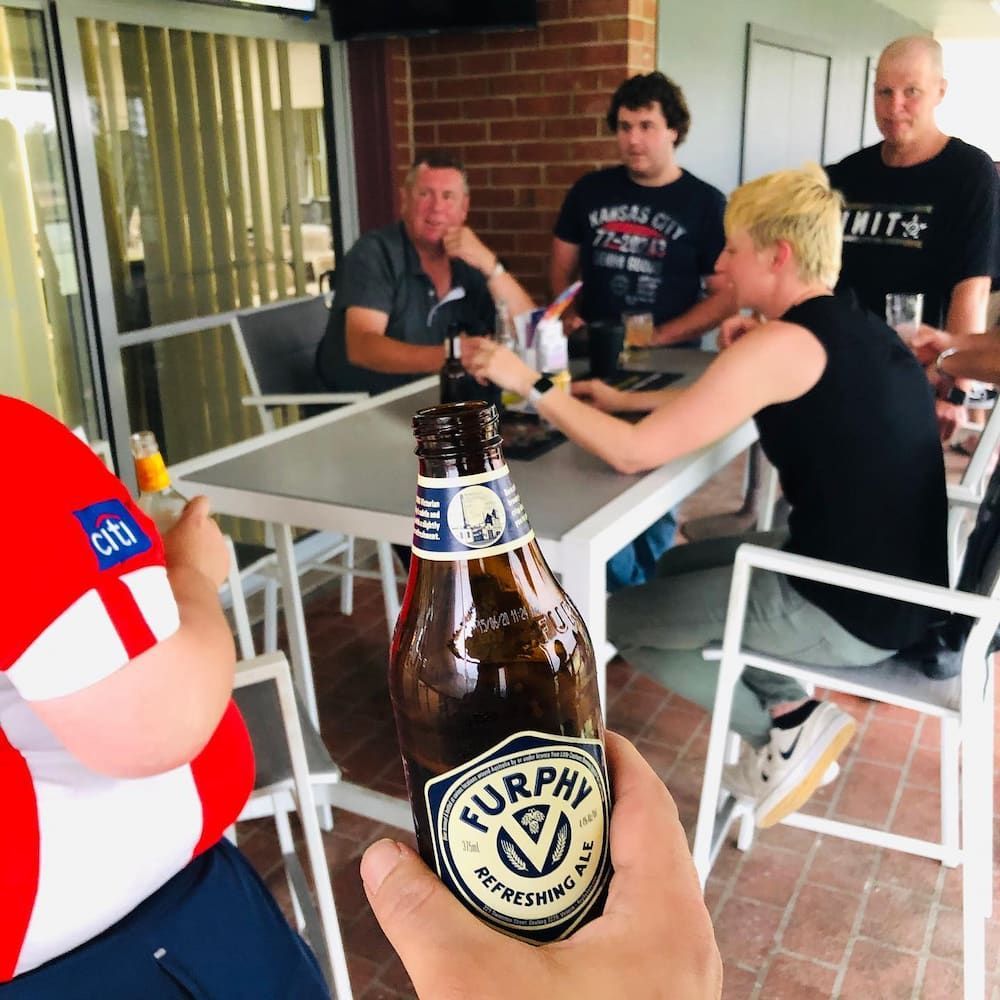 A Person Is Holding A Bottle Of Furphy Beer — Inverell Sporties in Inverell, NSW