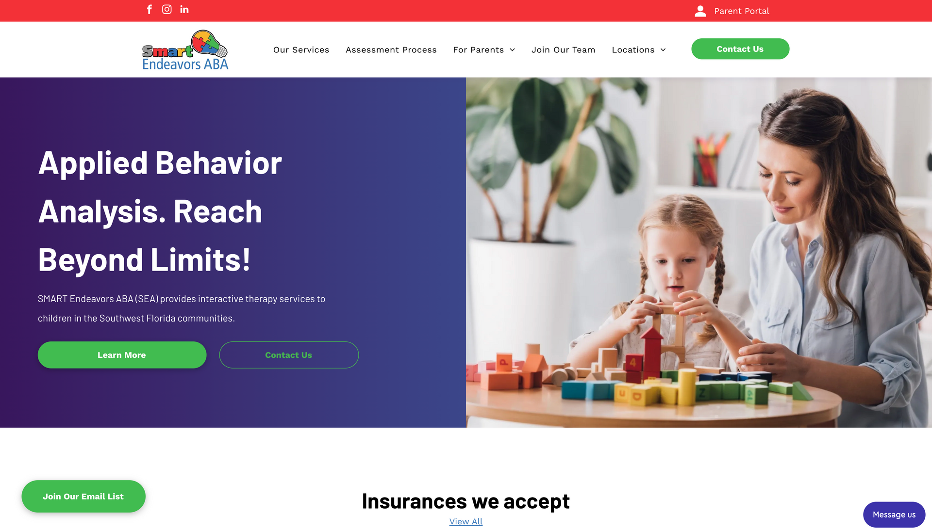 A woman is sitting at a table with a child playing with blocks.