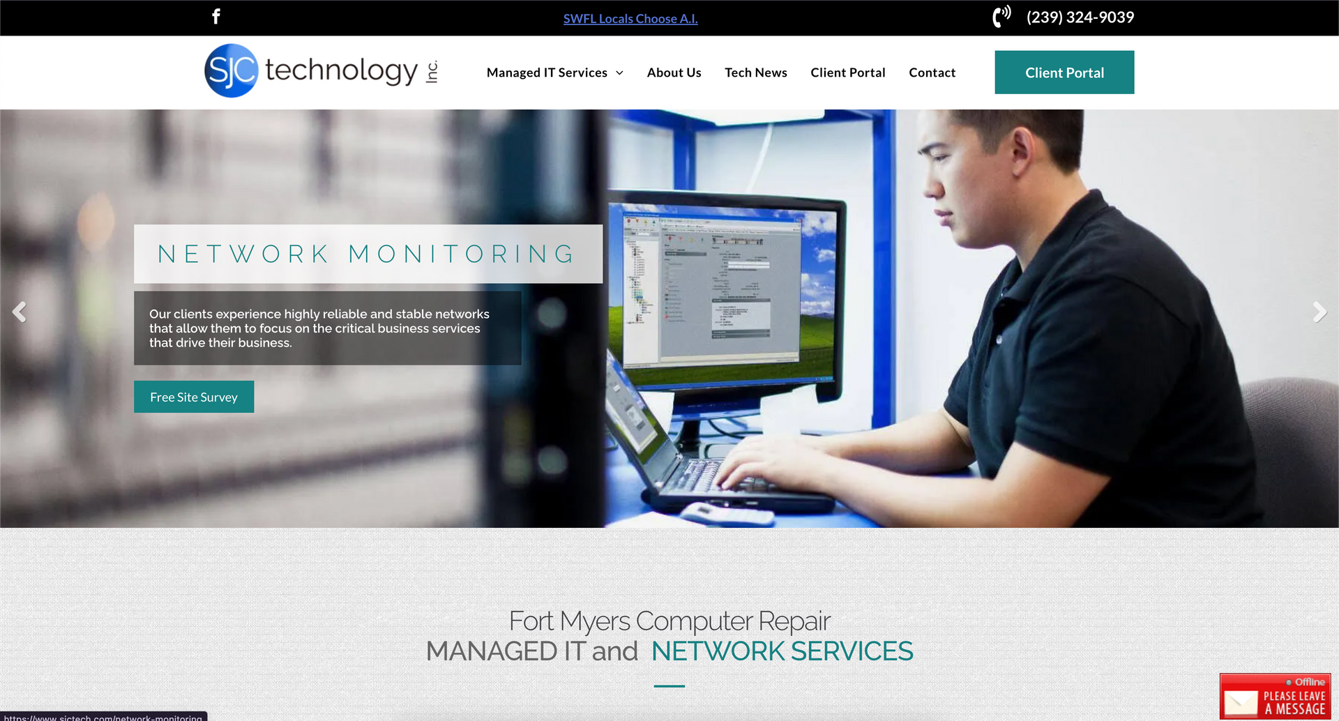 A man is sitting at a desk using a laptop computer.