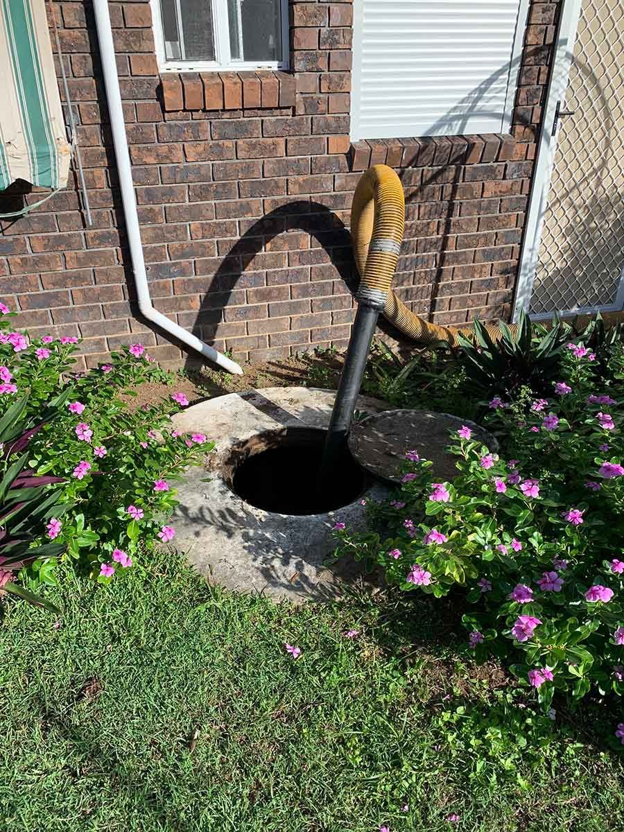 A Hose Is Coming Out Of A Septic Tank — Mackay Septic Pumping In South Mackay, QLD