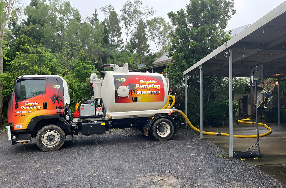 Septic Pumping Truck Parked Near a House, Hose Extended