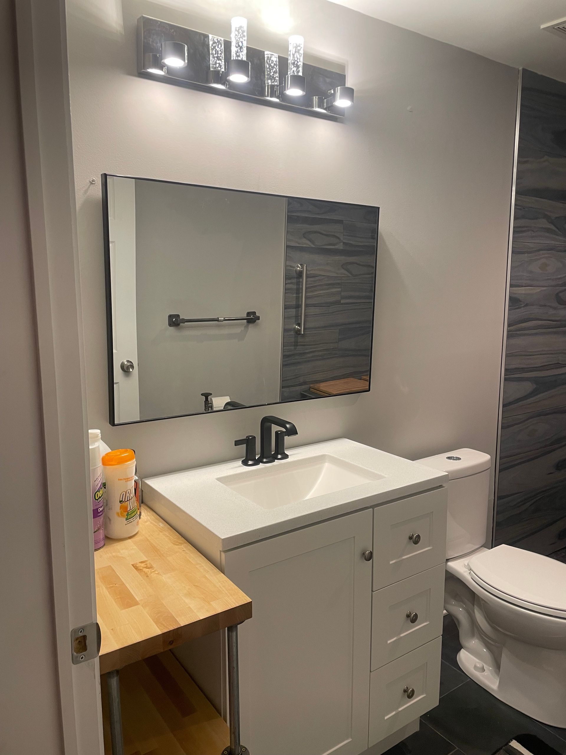 Bathroom with a white vanity, black faucet, and a decorative tile wall.
