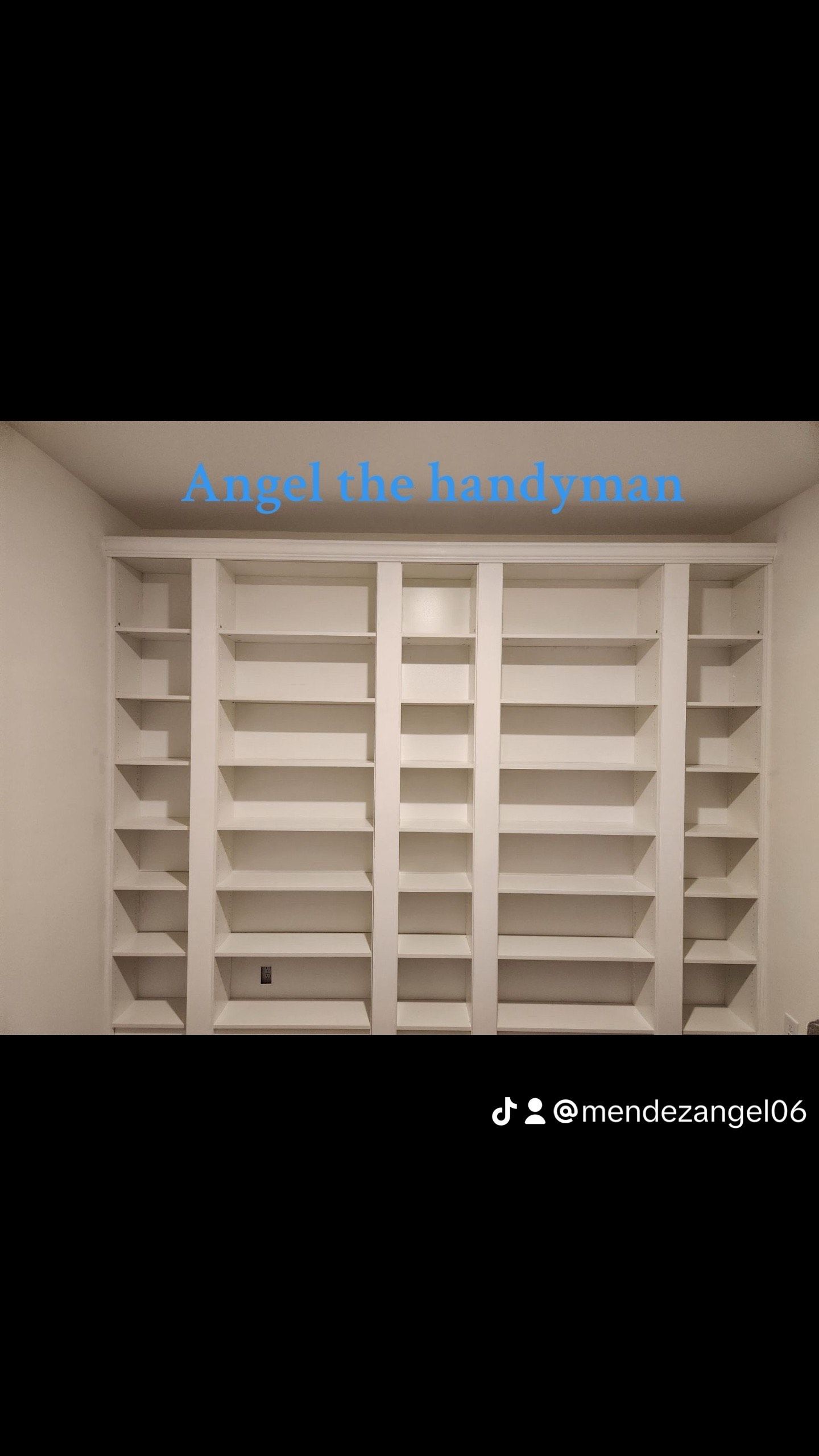 White built-in shelving unit with multiple shelves and cubbies against a white wall.