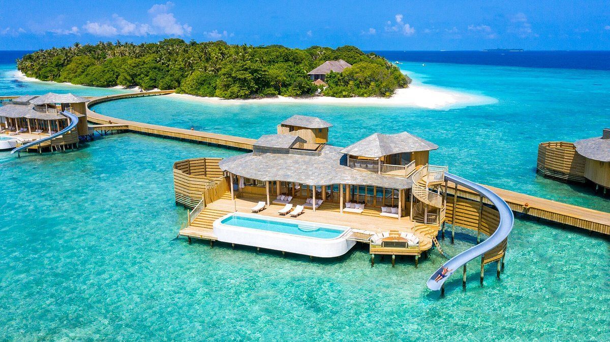 An aerial view of Soneva Fushi Maldives a villa on a small island in the middle of the ocean.