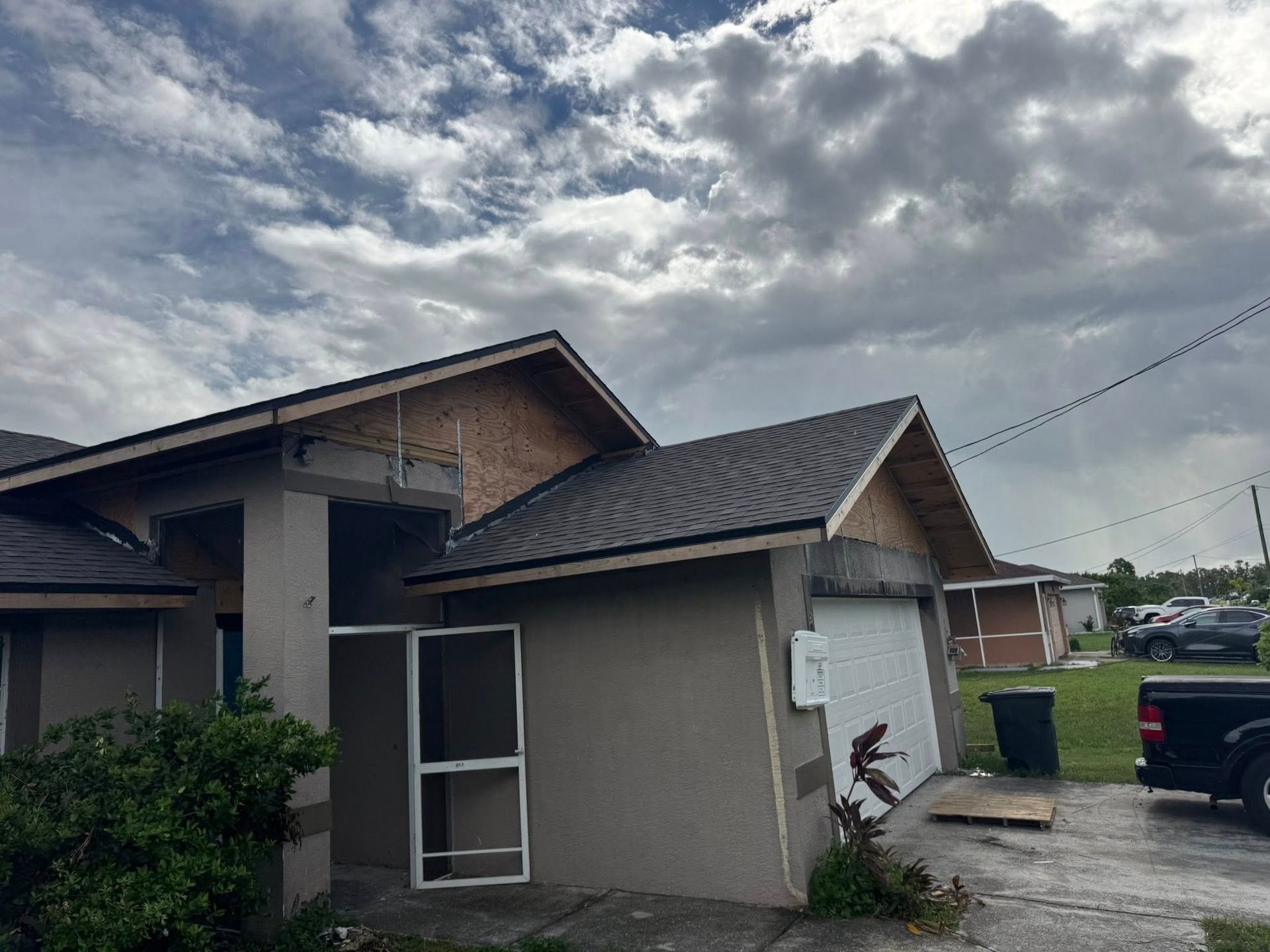 House with new roofing, partially constructed, under cloudy skies.