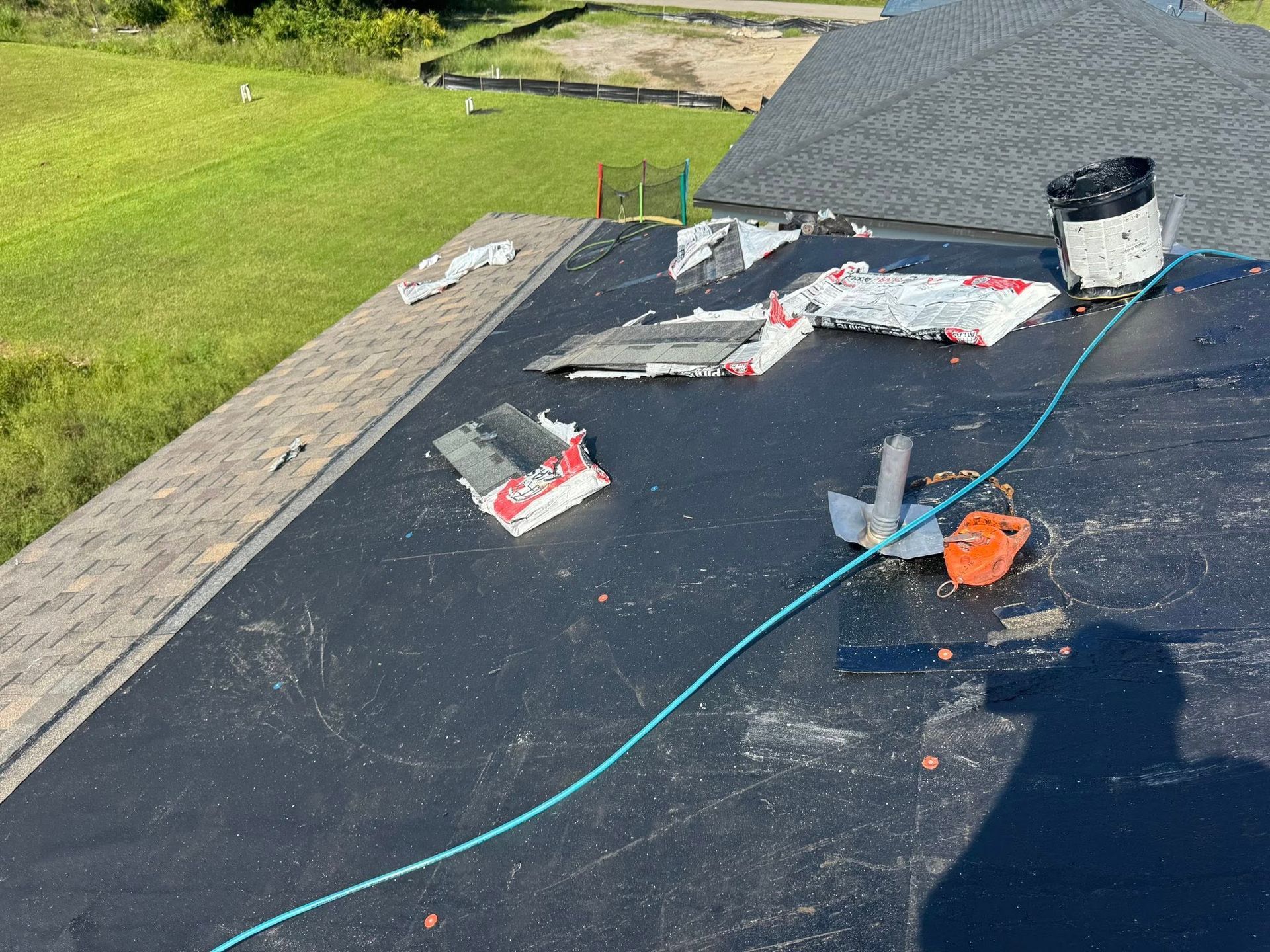 Rooftop with debris, equipment, and a safety rope. 