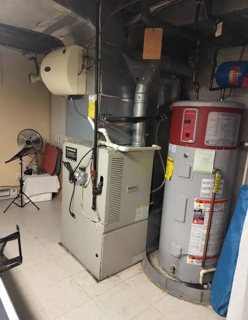 A room with a heater and a water heater in it.