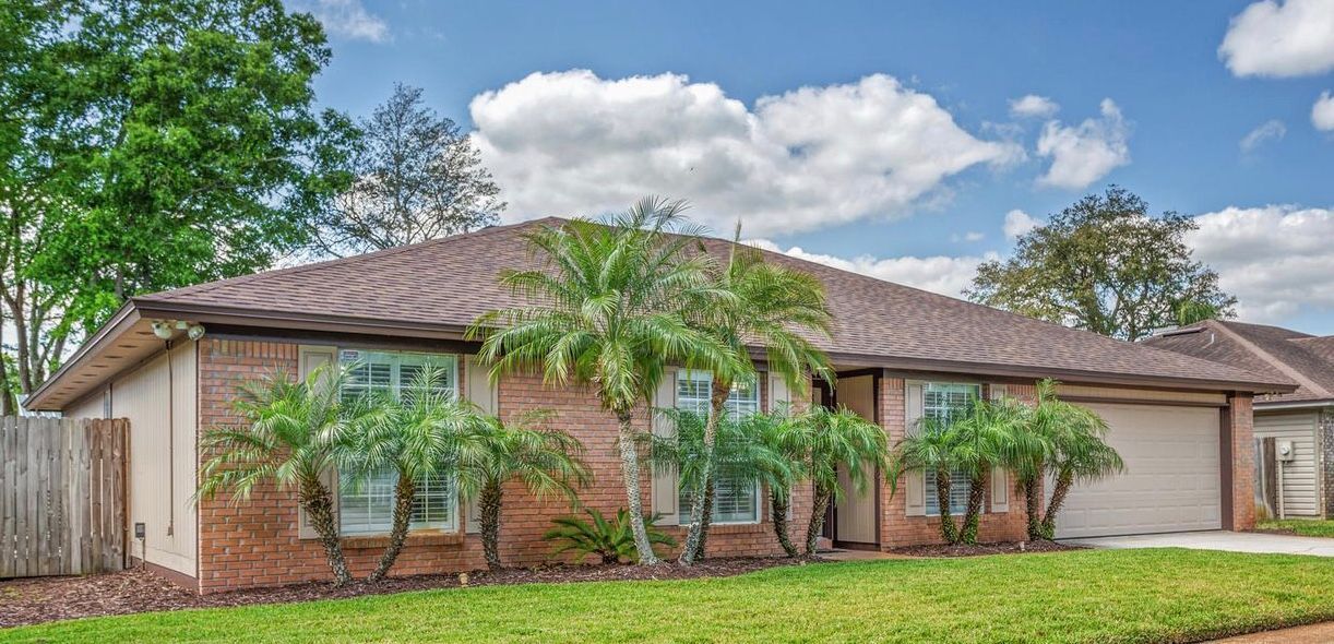 A brick house with palm trees in front of it