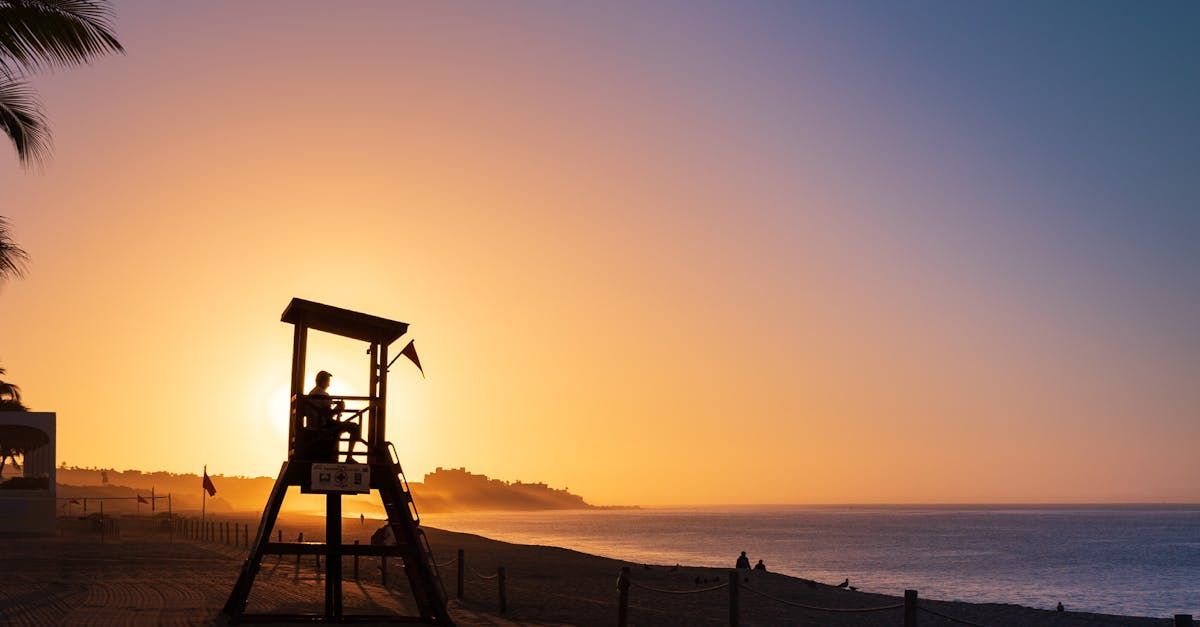 A lifeguard tower on a beach at sunset.