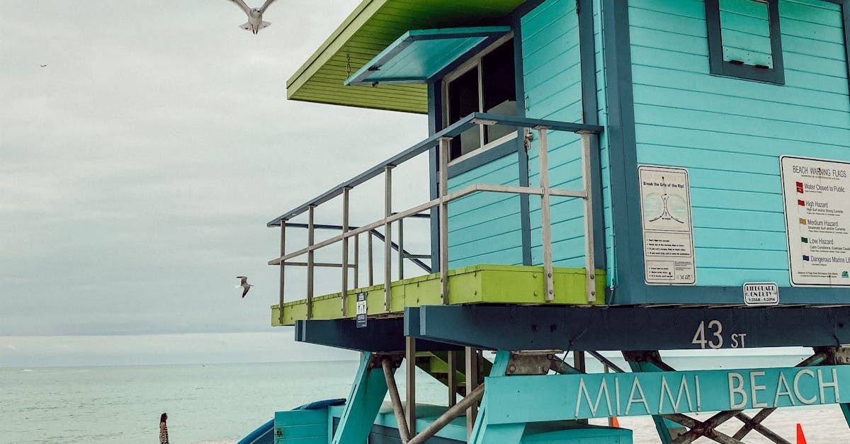 A blue and green lifeguard tower on the beach in miami.