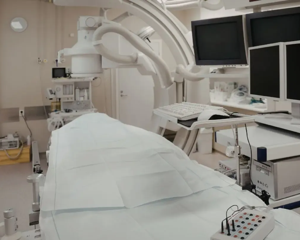 Operating room with sterile bed, medical equipment, and monitors.