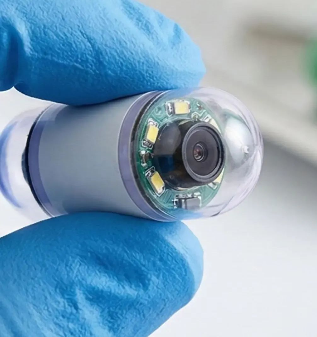 Smiling person in a hospital bed, wearing a hospital gown and looking up.