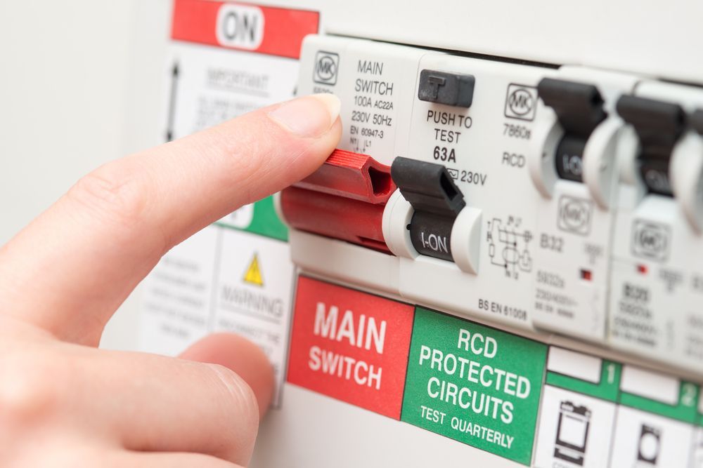 A Person Is Pressing A Red Button On A Main Switch — Chris North Electrical In Pomona, QLD
