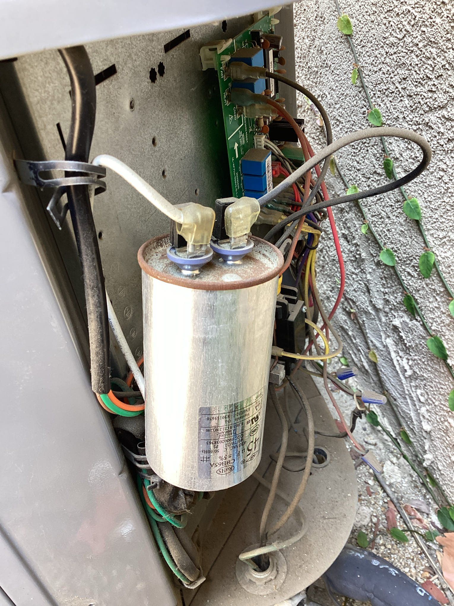 Air conditioner components: a capacitor and circuit board.