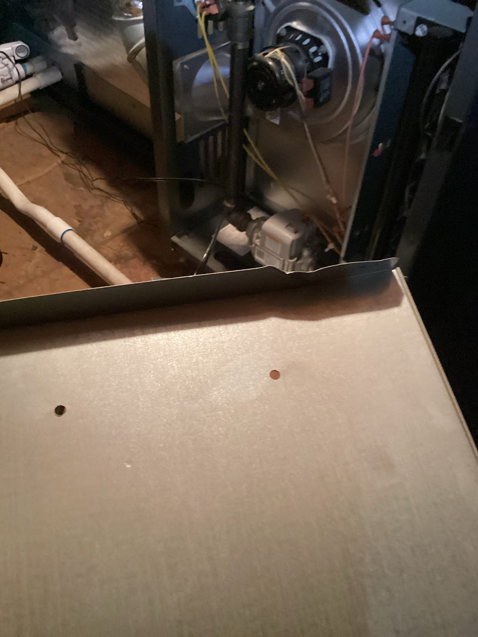 Metal furnace components with a blower and various wires.