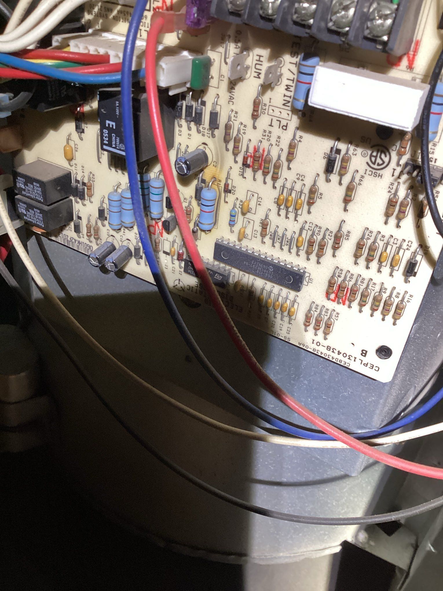 Circuit board with red, blue, and white wires connected to terminals and components.