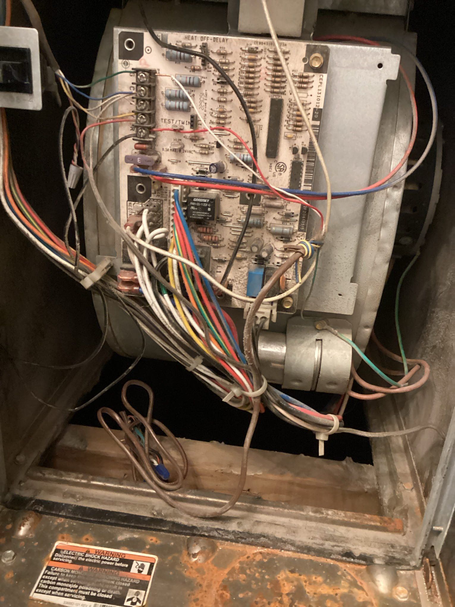 Circuit board inside a metal housing with numerous colored wires and electrical components.