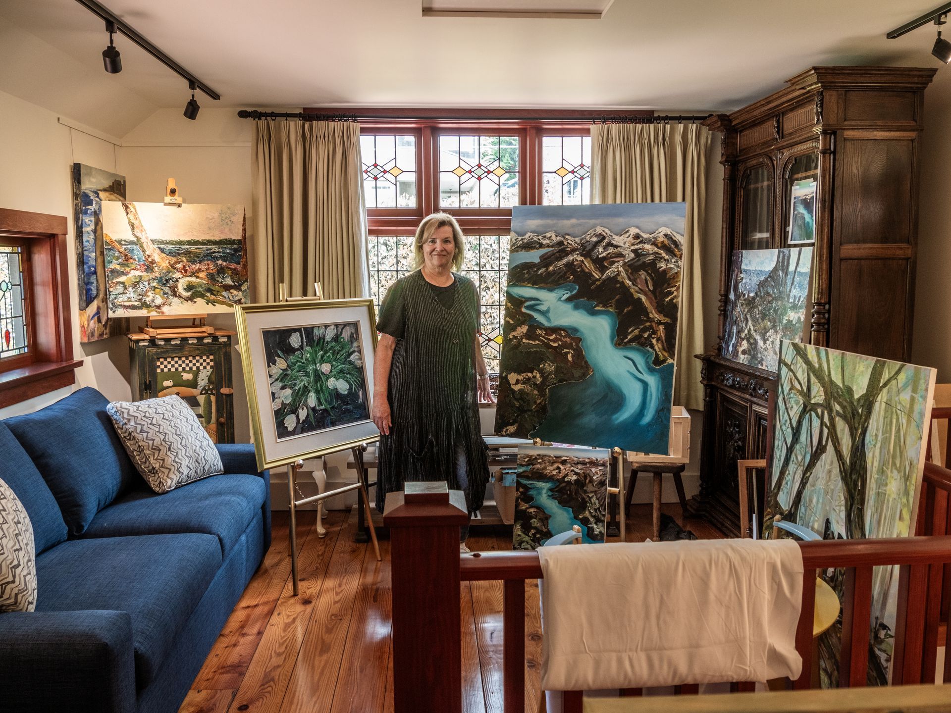Hilary Kerr standing next two two pieces of art work in her studio smiling.
