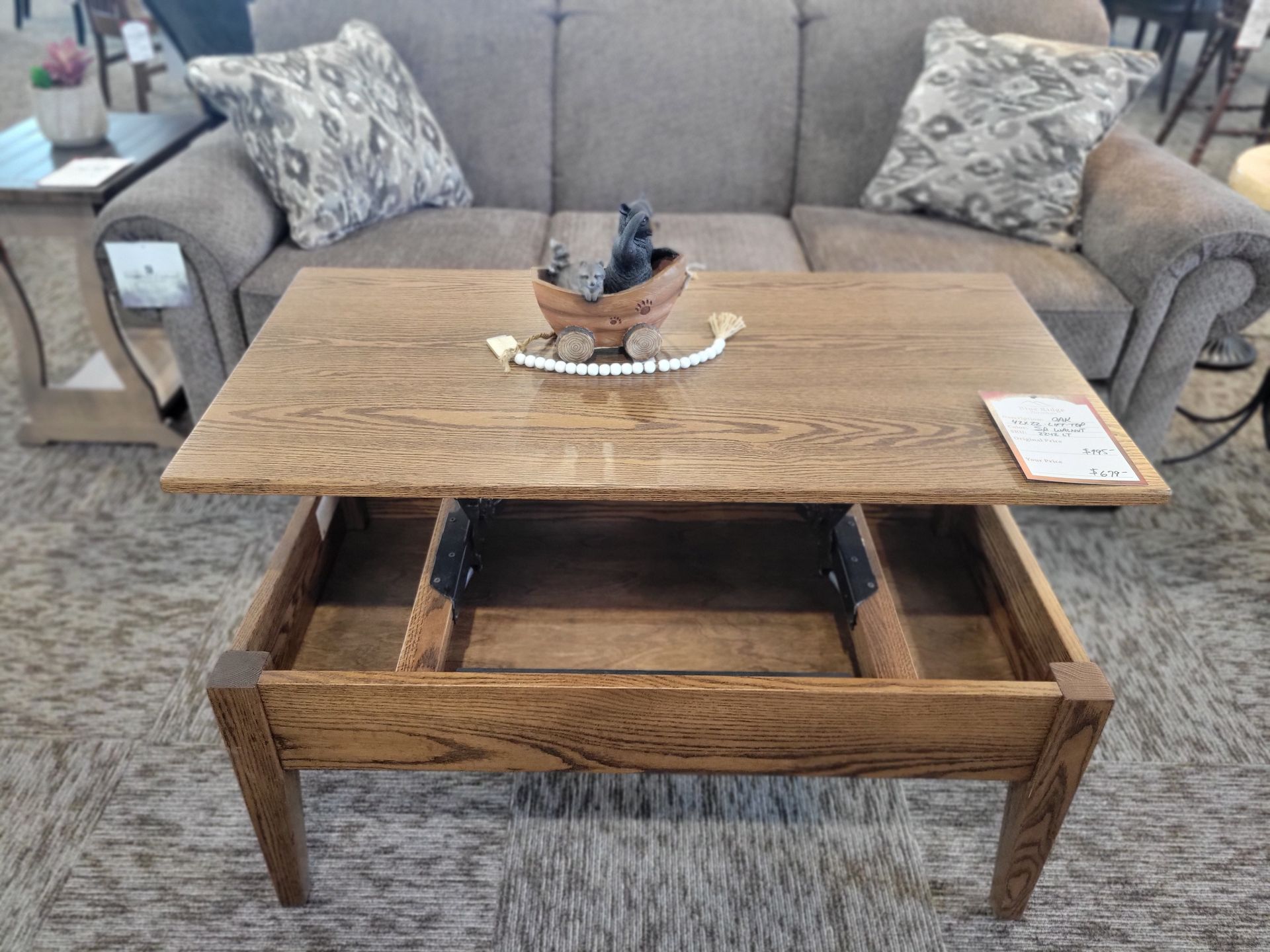 A wooden coffee table is sitting in a living room next to a couch.