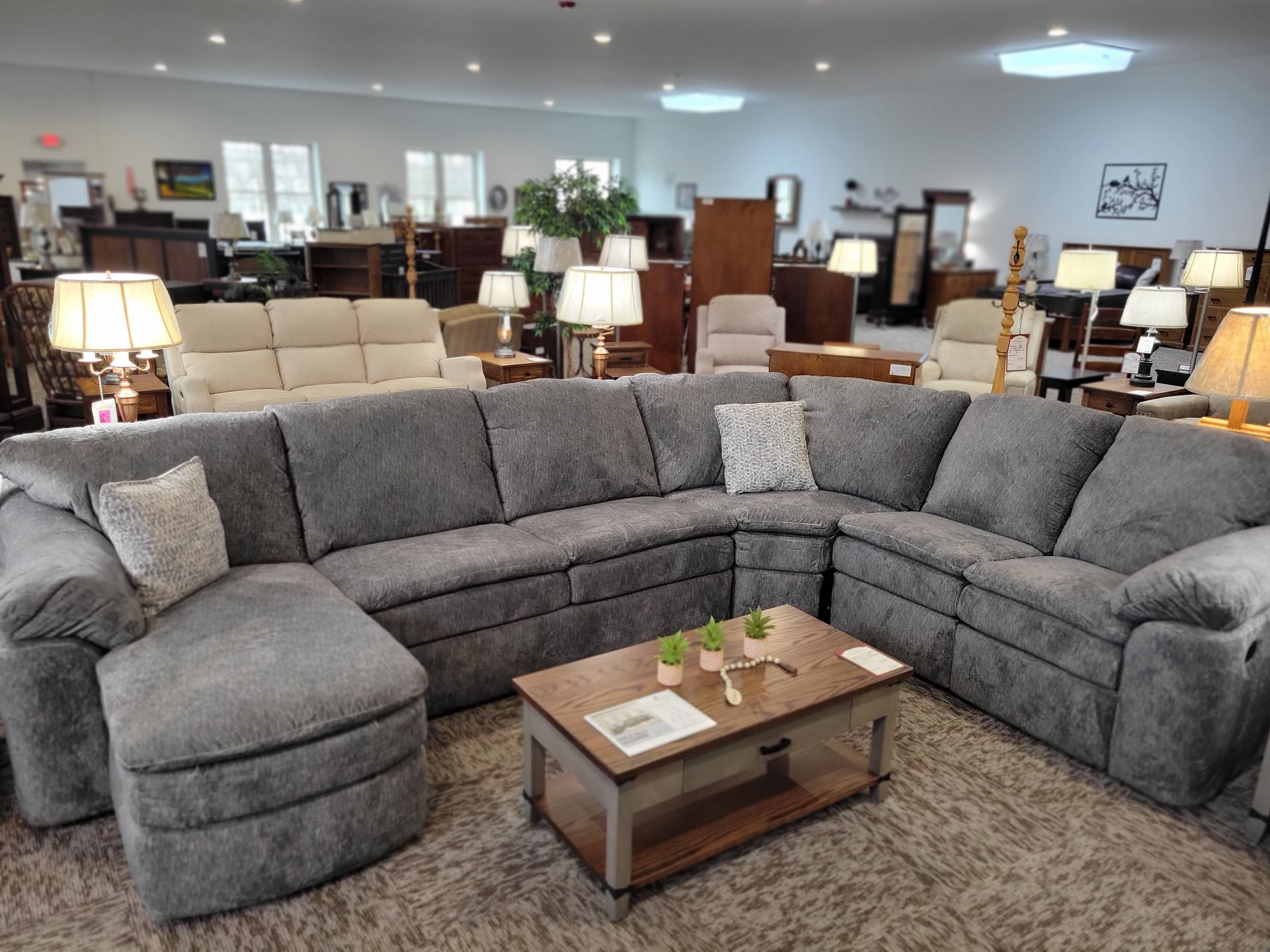 A living room with a large sectional couch and a coffee table.