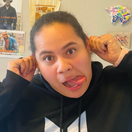 A woman wearing a black hoodie is sticking her tongue out