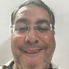A man wearing glasses is smiling for the camera.