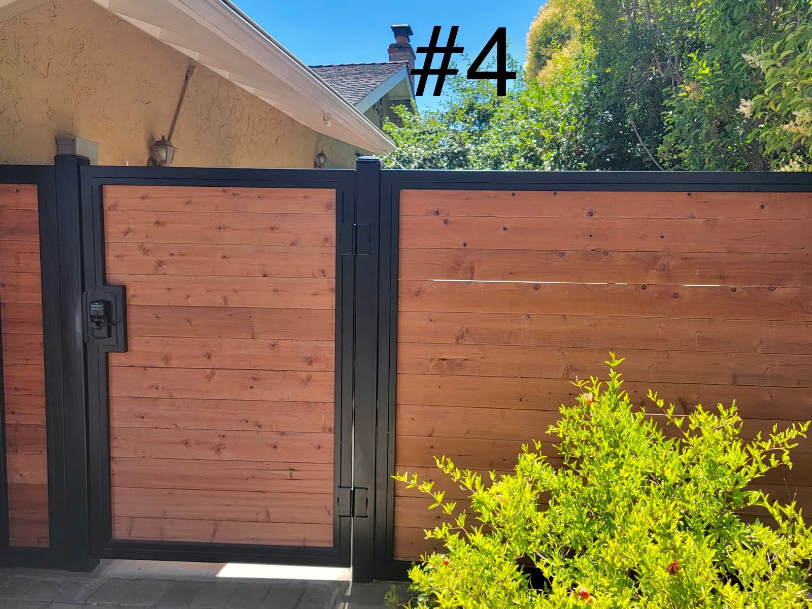 A modern horizontal wood fence with a black metal frame.
