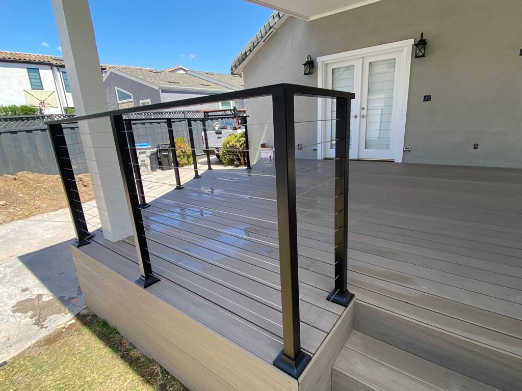 Composite deck with black railing and white French doors.
