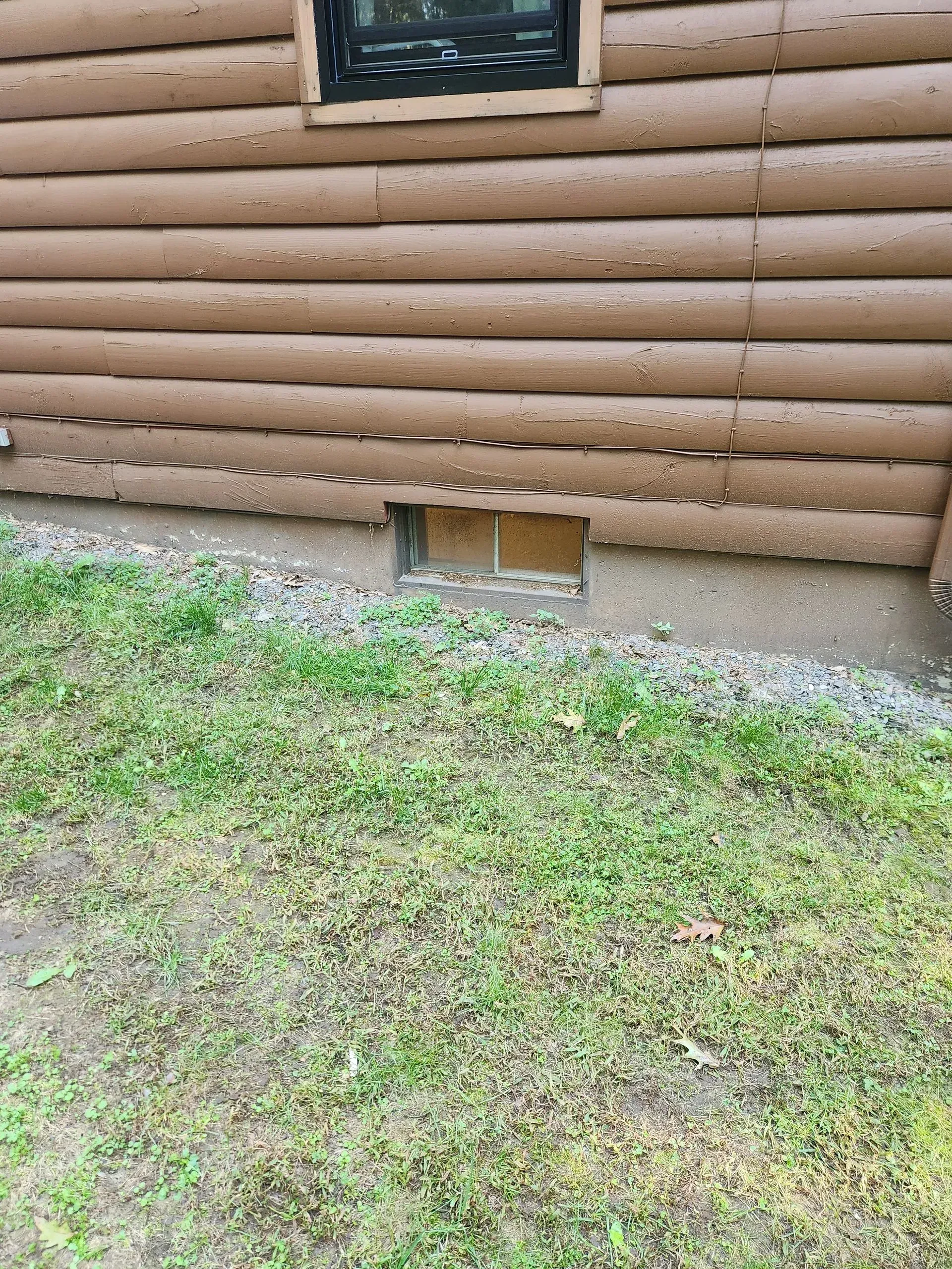 A log cabin with a window in the side of it.