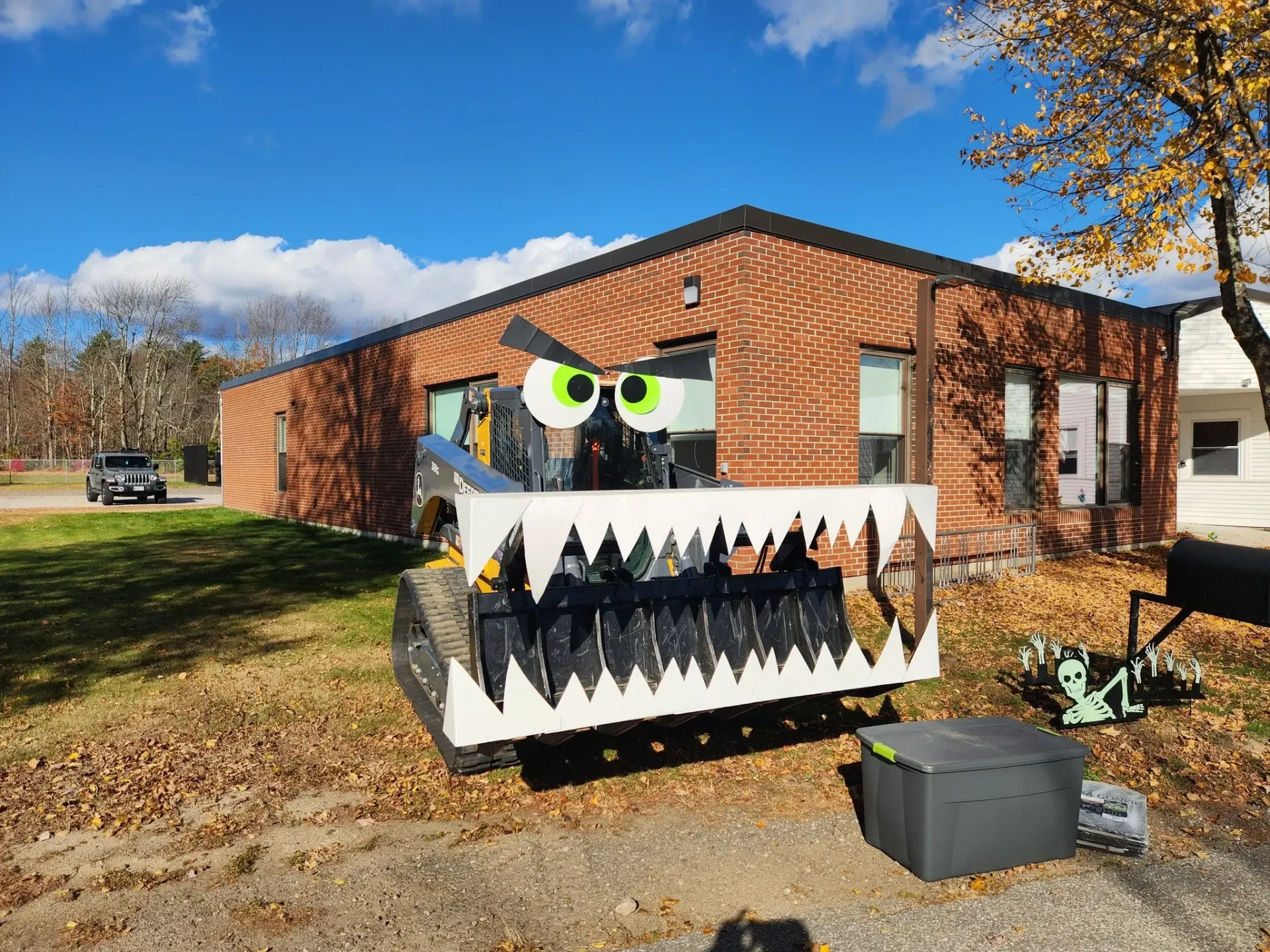A brick building with a monster truck in front of it.