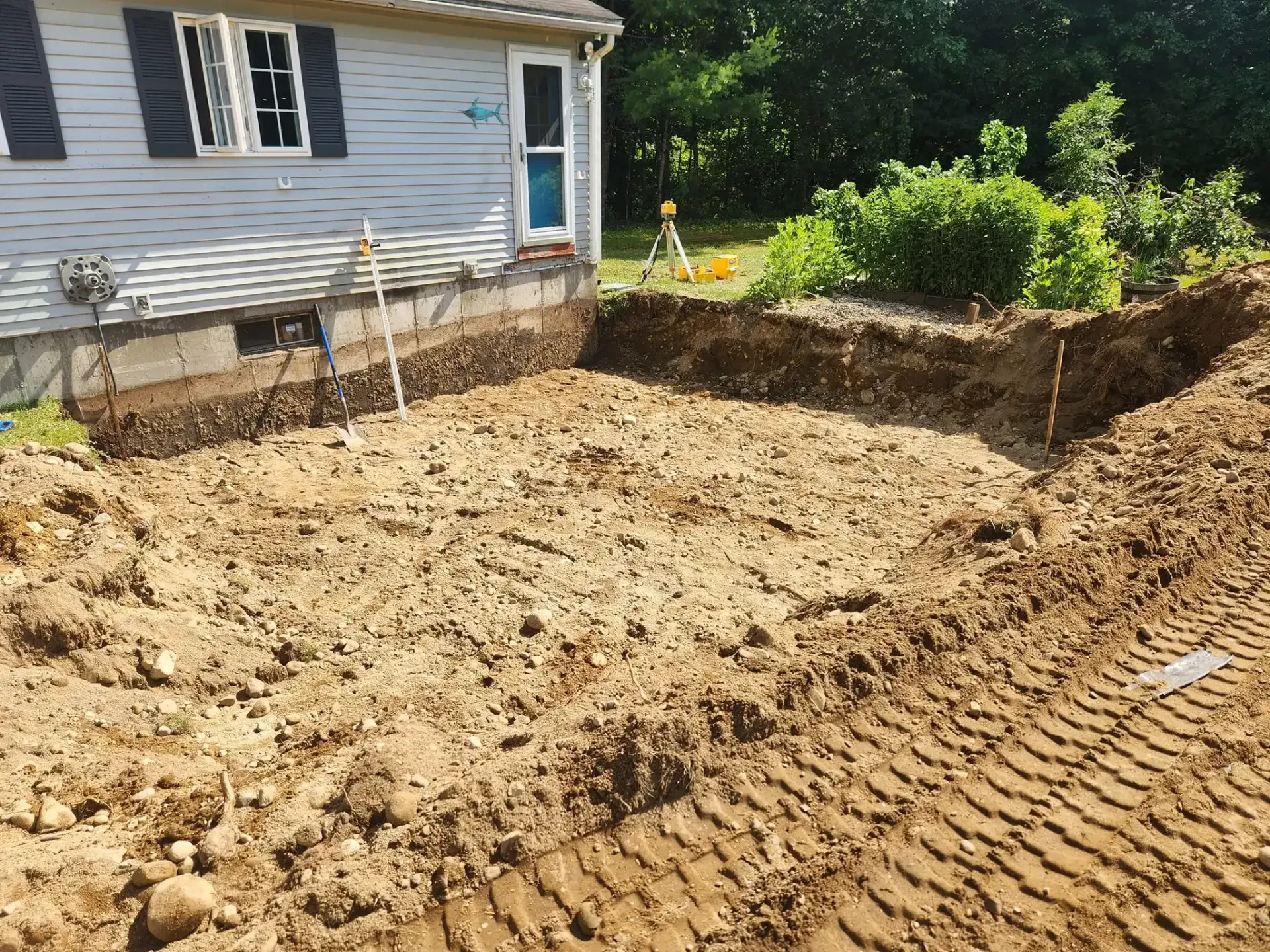 A large pile of dirt is in front of a house.