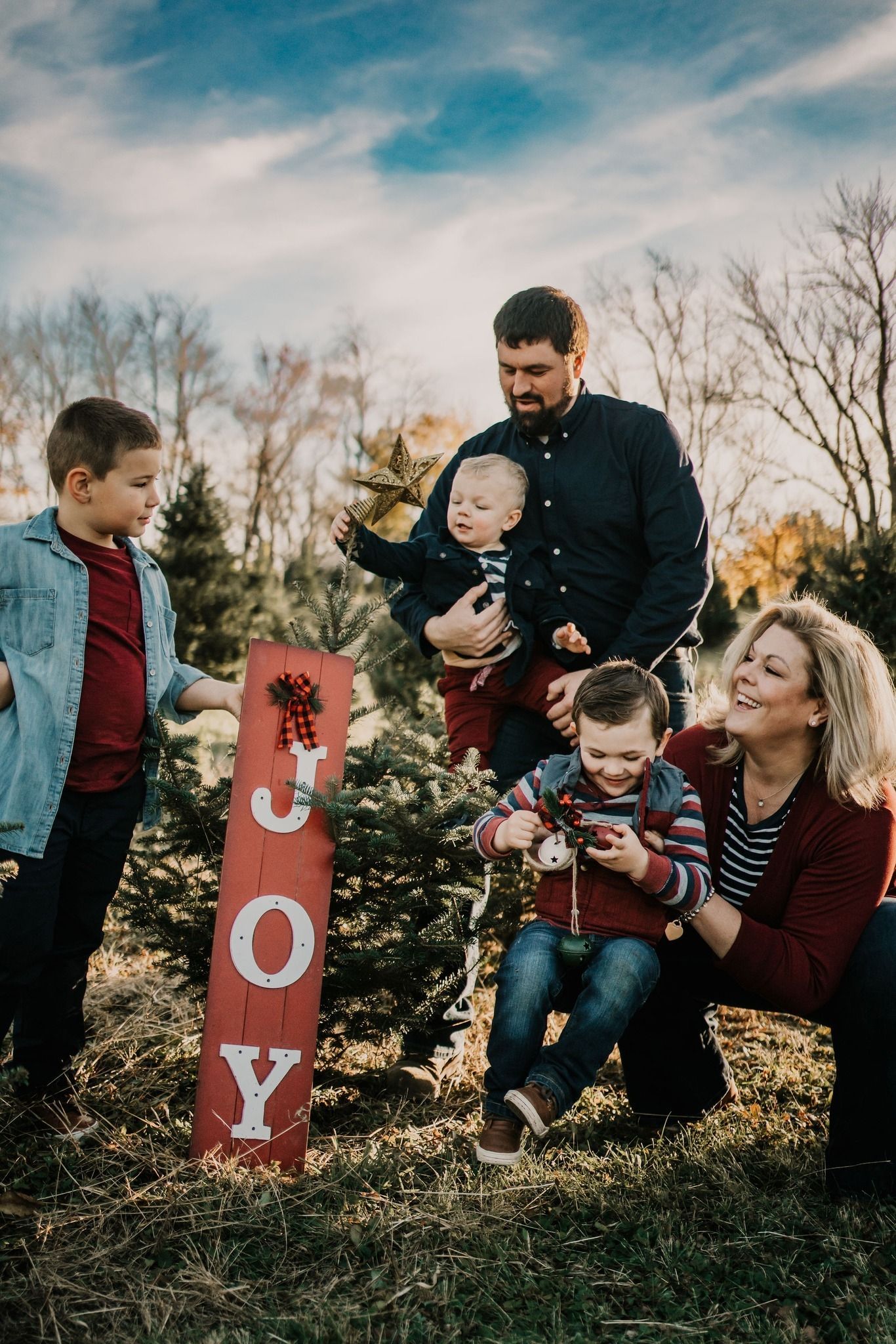 A family is cutting down a christmas tree at a christmas tree farm.