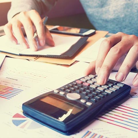 Tax Preparation — Man Using Calculator in Bronx, NY