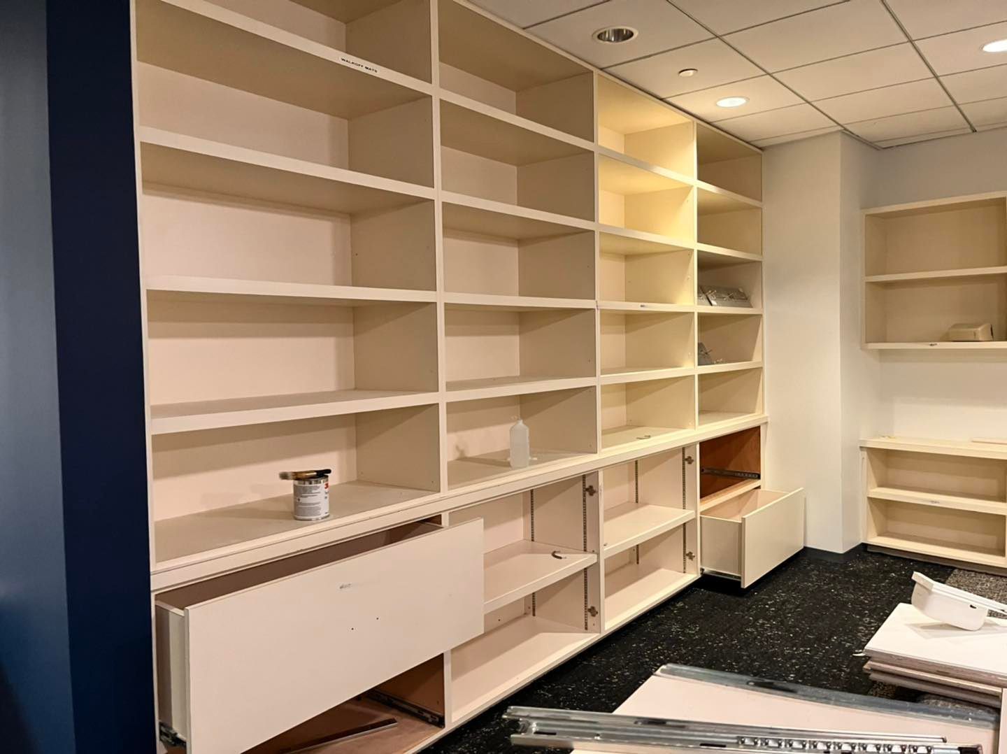 A room with a lot of shelves and drawers.