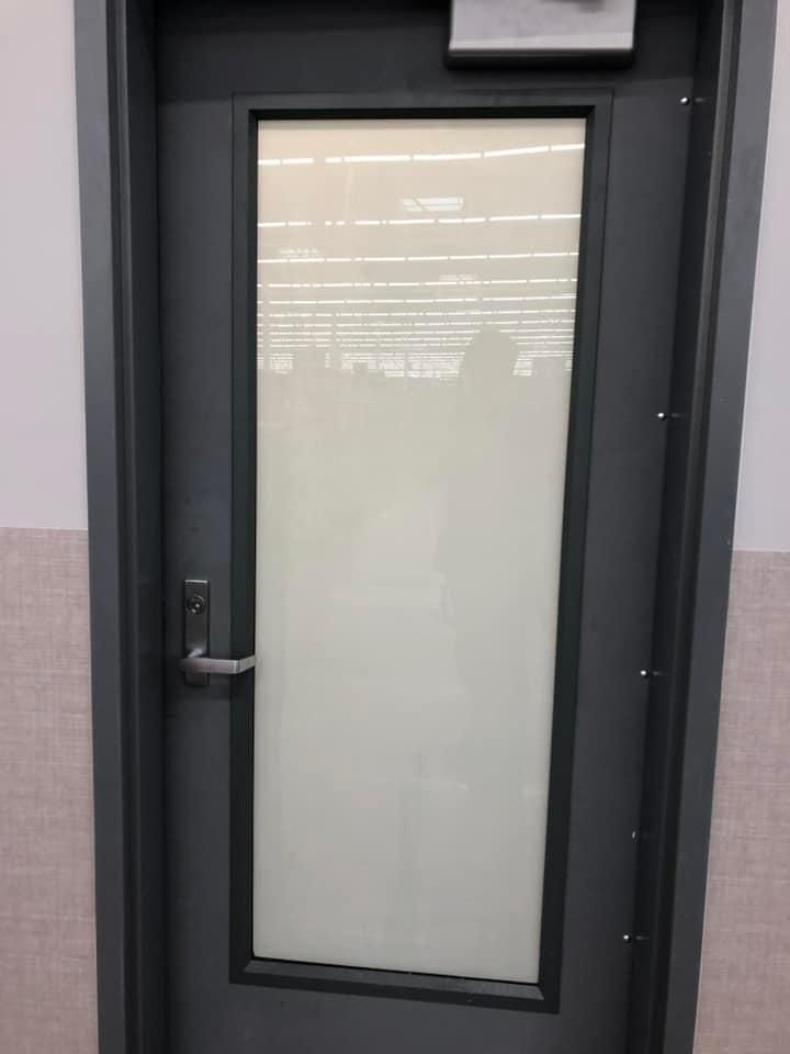 A door with a white glass window and a black frame.