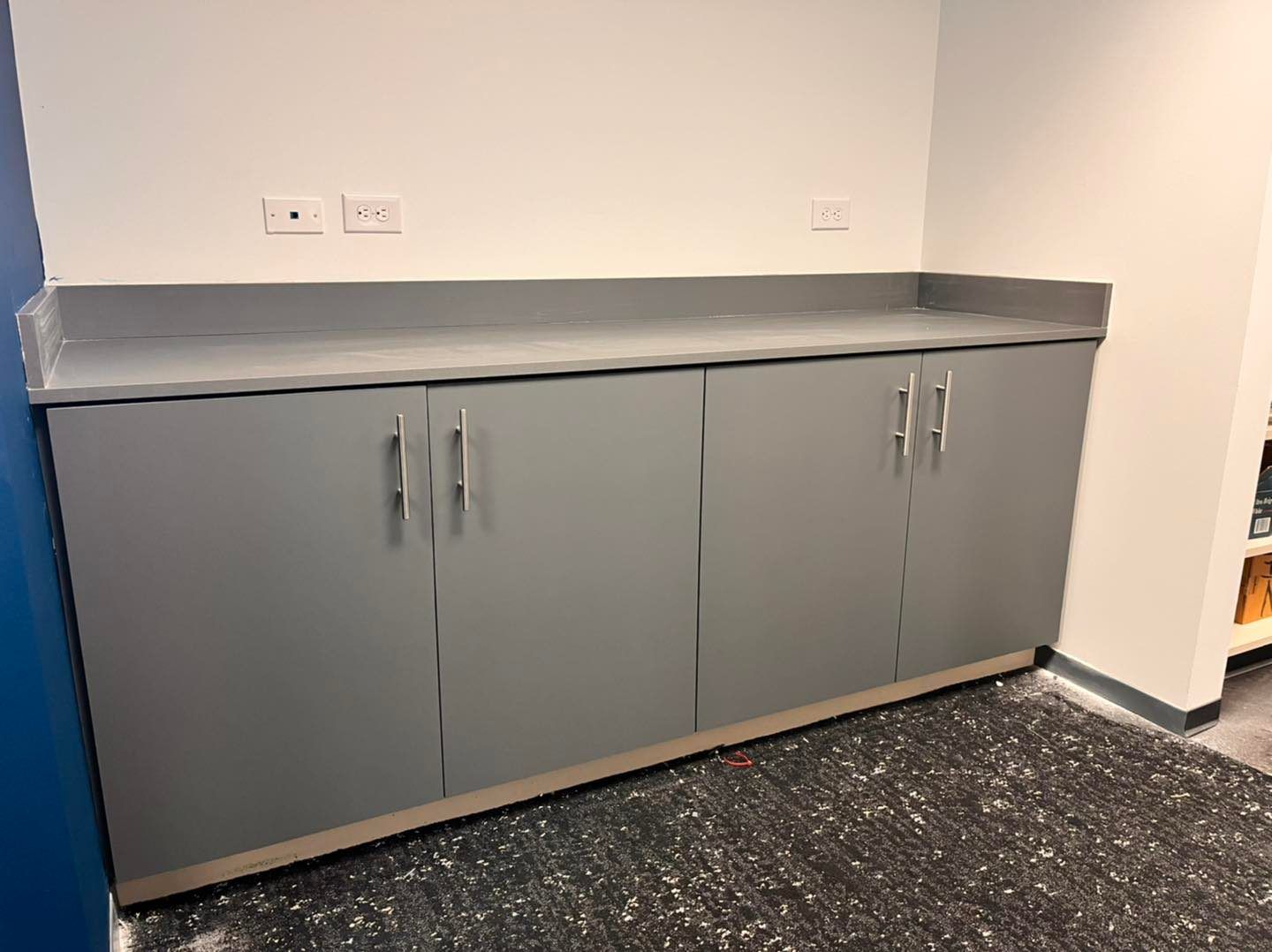 A kitchen with gray cabinets and a counter top.