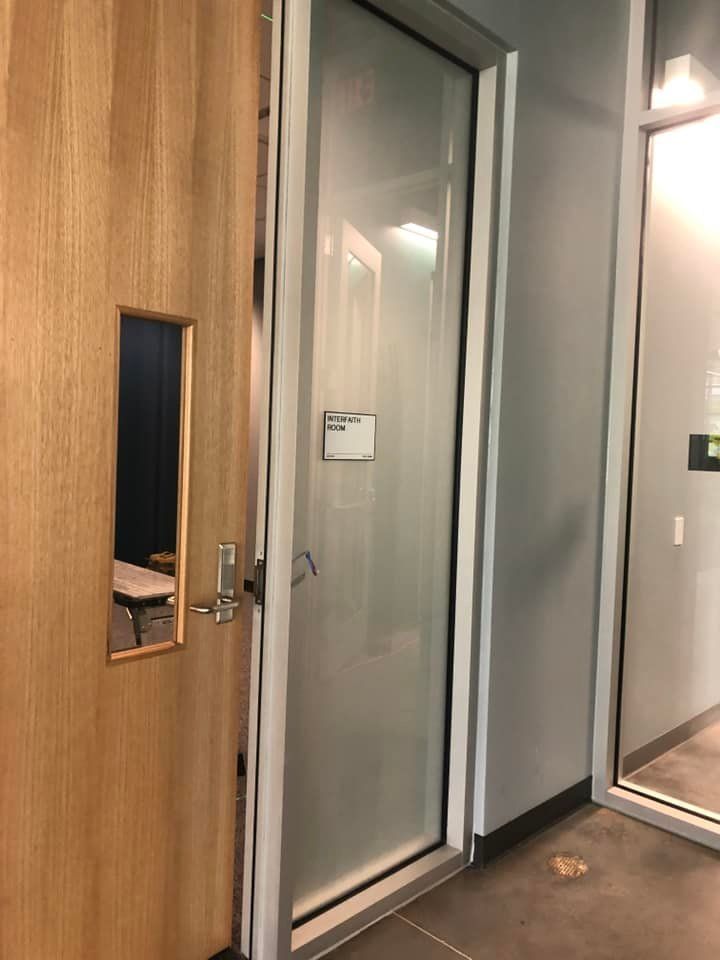 A wooden door with a glass door in a room.